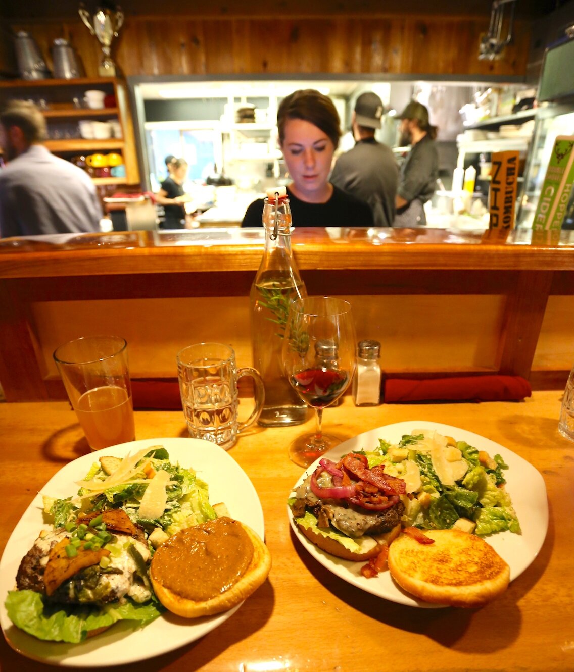 Marc Donadieu / Glacier City Gazette The Jammin Jerk Burger (L) and the Mountain Mushroom Burger (R) deliver a lot of flavor. Server Natalie Leeper is seen over the small bar that overlooks the kitchen's ballet.