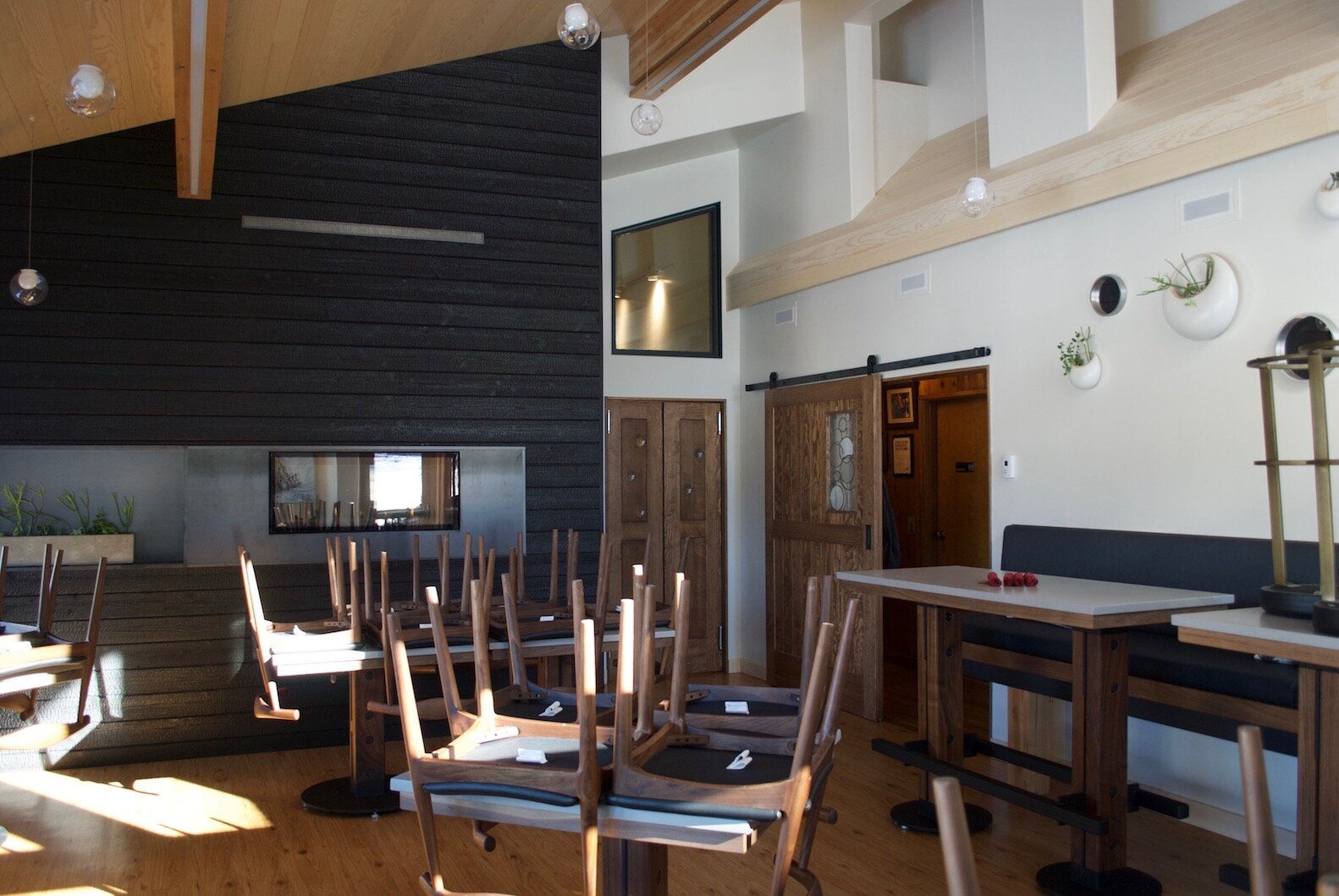 Peter Erickson / Glacier City Gazette Co-owner Jen Weits designed the interior of the new dining room, which includes charred wood on the walls to add contrast to the rest of the space.